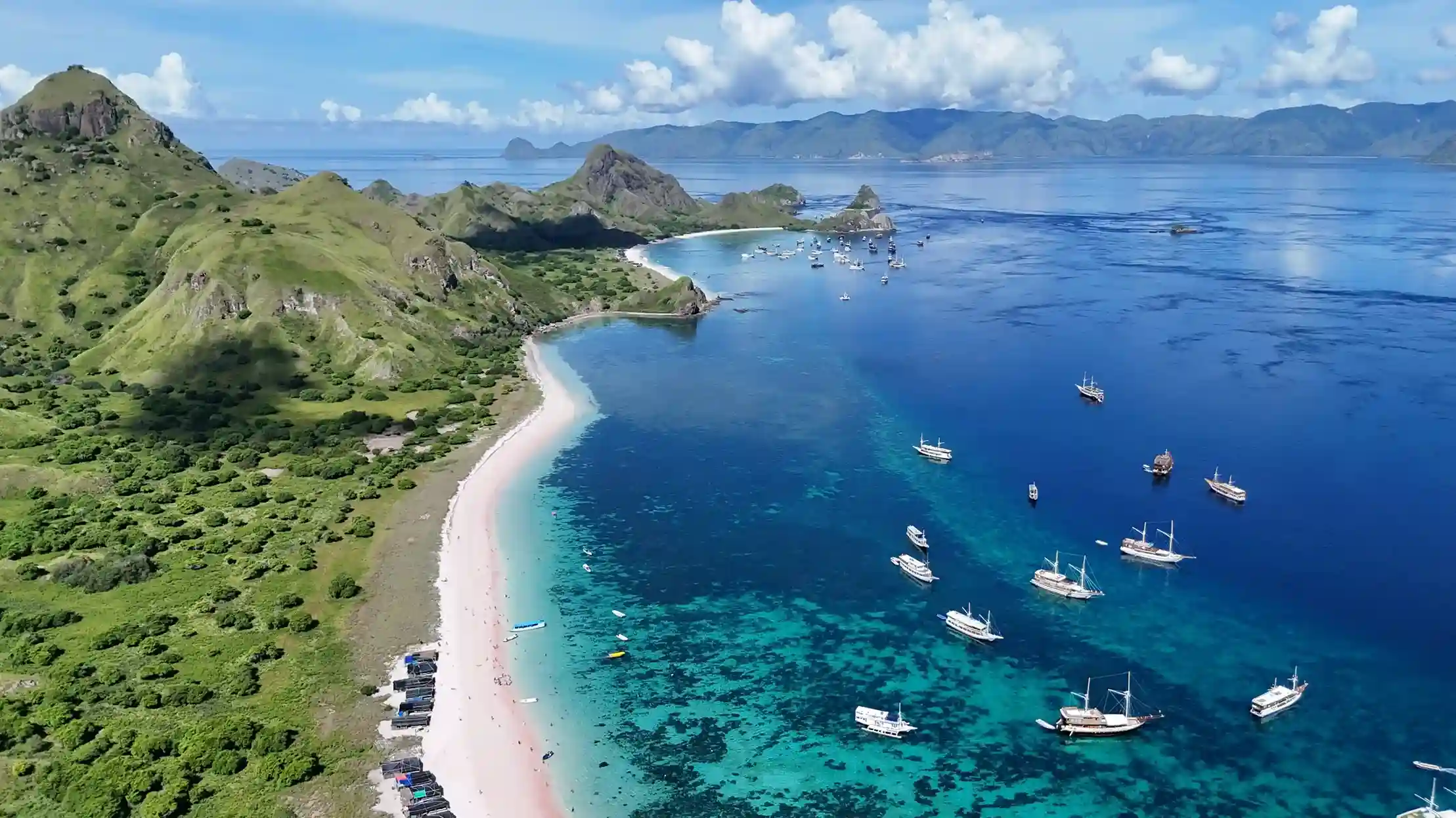 Boats anchored off the rose-coloured sand of Pink Beach
